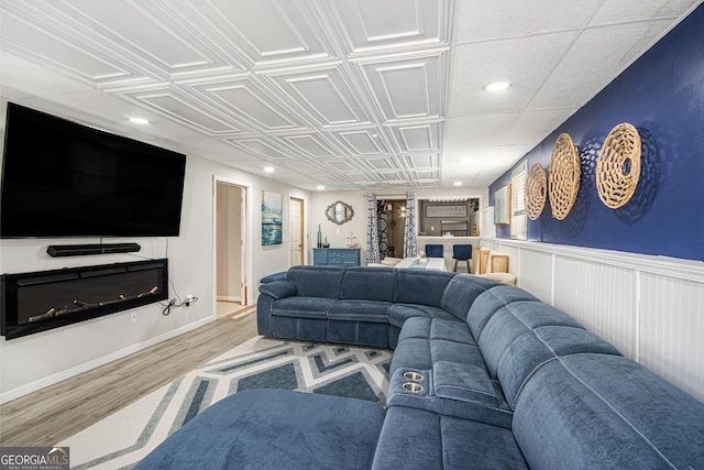 living area with an ornate ceiling, recessed lighting, baseboards, and wood finished floors