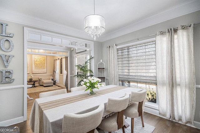 dining area with crown molding, dark wood finished floors, and a chandelier
