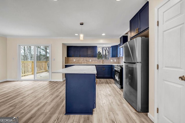 8443 Park Ridge Ln, Riverdale, GA 30274 - kitchen featuring light countertops, freestanding refrigerator, blue cabinets, a center island, and gas range