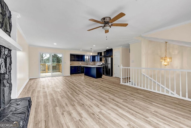 8443 Park Ridge Ln, Riverdale, GA 30274 - unfurnished living room featuring baseboards, ornamental molding, a sink, light wood-style floors, and ceiling fan with notable chandelier