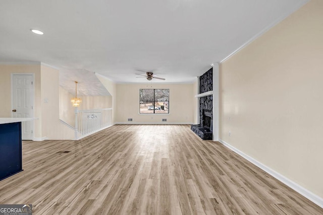 8443 Park Ridge Ln, Riverdale, GA 30274 - unfurnished living room with a large fireplace, crown molding, ceiling fan with notable chandelier, and light wood finished floors