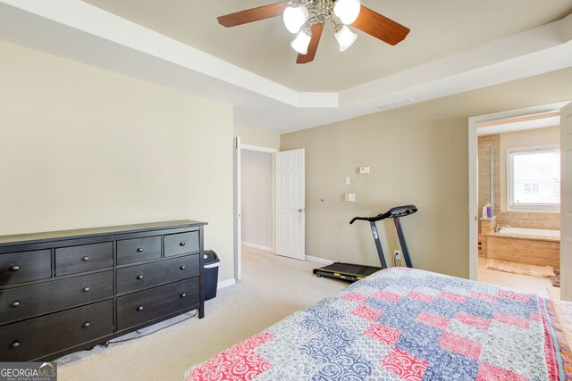 bedroom with a raised ceiling, light carpet, ensuite bathroom, baseboards, and visible vents