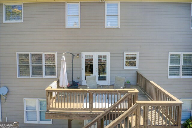 back of property with outdoor dining area, stairs, and a wooden deck
