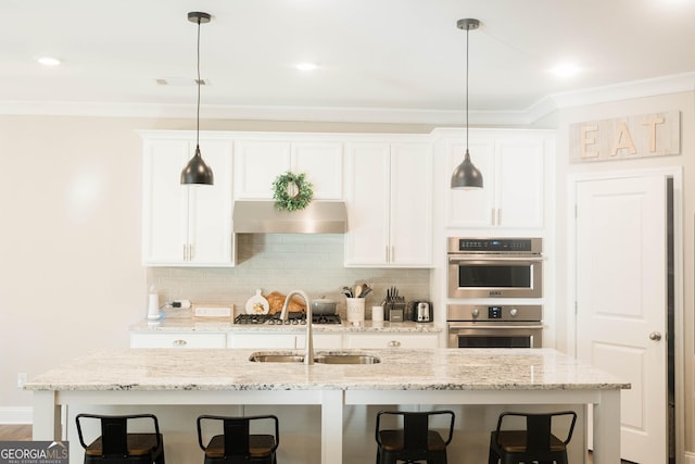 5745 Pickens Garden Ln, Powder Springs, GA 30127 - kitchen with a breakfast bar, stainless steel appliances, ornamental molding, white cabinetry, and decorative backsplash