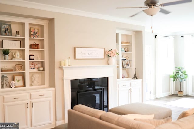 5745 Pickens Garden Ln, Powder Springs, GA 30127 - living area with a glass covered fireplace, ceiling fan, ornamental molding, and wood finished floors