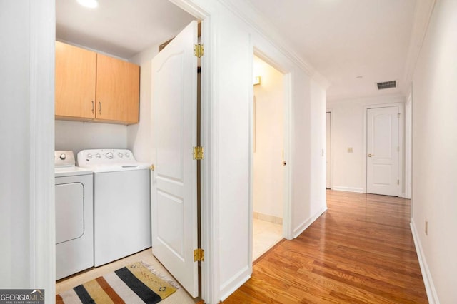 195 14th St NE Ph 306, Atlanta, GA 30309 - laundry room with washing machine and clothes dryer, light wood finished floors, cabinet space, and baseboards