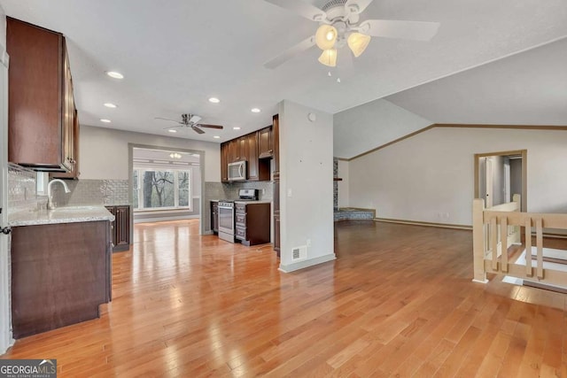 2285 Bascomb Carmel Rd, Woodstock, GA 30189 - kitchen featuring appliances with stainless steel finishes, ceiling fan, light wood finished floors, backsplash, and recessed lighting