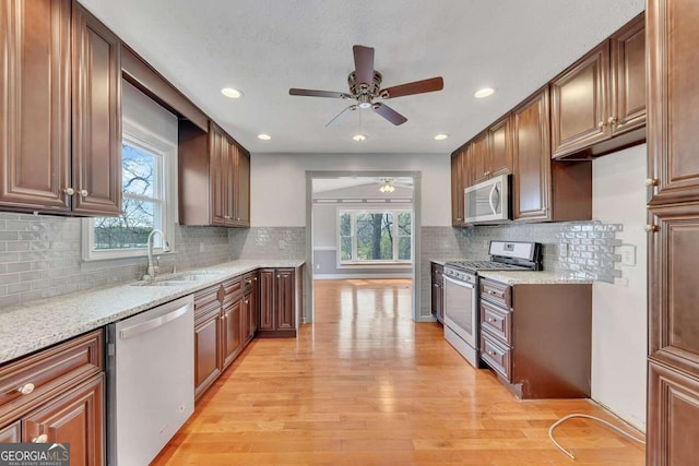 2285 Bascomb Carmel Rd, Woodstock, GA 30189 - kitchen featuring appliances with stainless steel finishes, a ceiling fan, light wood finished floors, healthy amount of natural light, and recessed lighting
