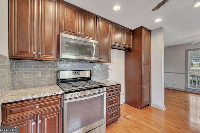 2285 Bascomb Carmel Rd, Woodstock, GA 30189 - kitchen with stainless steel appliances, backsplash, light stone counters, light wood-style flooring, and recessed lighting