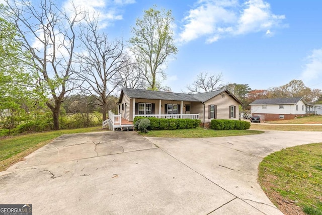 2285 Bascomb Carmel Rd, Woodstock, GA 30189 - view of front of home featuring a porch, concrete driveway, and a front lawn