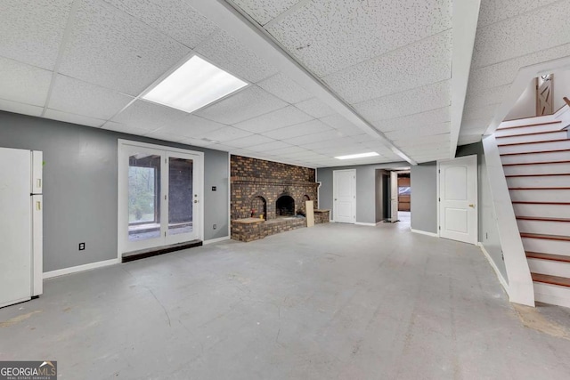 2285 Bascomb Carmel Rd, Woodstock, GA 30189 - unfurnished living room featuring stairway, concrete flooring, a fireplace, and a drop ceiling