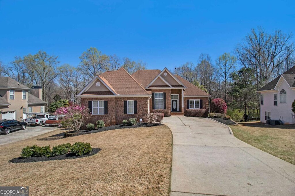 160 Glenmore Ln, Mcdonough, GA 30253 - view of front facade featuring a front yard, brick siding, concrete driveway, and central air condition unit