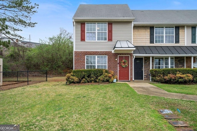413 W I Pkwy, Dallas, GA 30132 - view of front of home with a standing seam roof, fence, a front lawn, brick siding, and a shingled roof