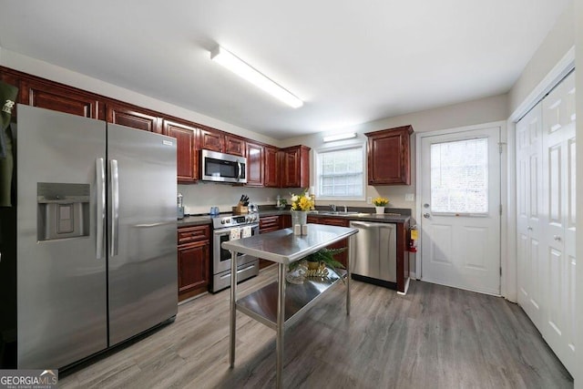 413 W I Pkwy, Dallas, GA 30132 - kitchen featuring dark countertops, light wood-style flooring, appliances with stainless steel finishes, and dark brown cabinets