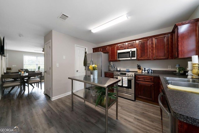 413 W I Pkwy, Dallas, GA 30132 - kitchen featuring a sink, appliances with stainless steel finishes, dark countertops, visible vents, and dark brown cabinets