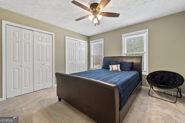 bedroom with carpet floors, baseboards, ceiling fan, and a textured ceiling