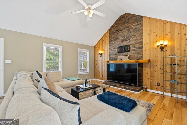 living room with lofted ceiling, light wood finished floors, a ceiling fan, and baseboards