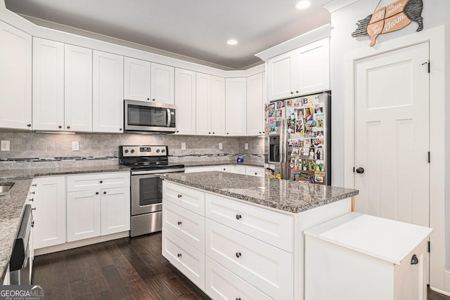 2129 Apalachee Trl, Monroe, GA 30656 - kitchen with appliances with stainless steel finishes, dark wood-style flooring, a center island, recessed lighting, and white cabinets