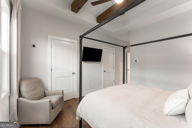 bedroom with beamed ceiling, dark wood-type flooring, and a ceiling fan