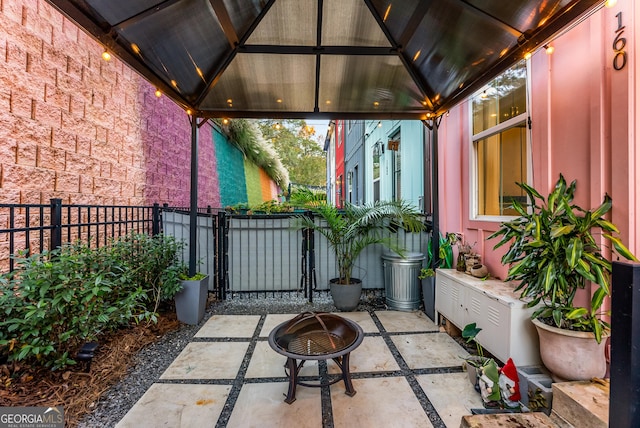 view of patio / terrace with an outdoor fire pit, a gazebo, fence, and a gate