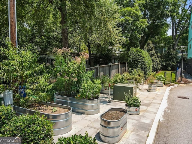 view of home's community featuring a garden and fence