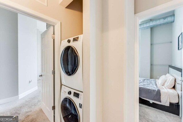 3820 Roswell Rd NE Unit 902, Atlanta, GA 30342 - laundry area with stacked washer and dryer, carpet, baseboards, and laundry area