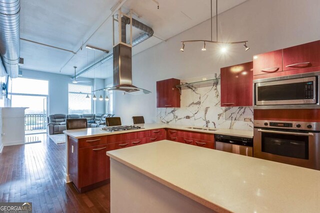 3820 Roswell Rd NE Unit 902, Atlanta, GA 30342 - kitchen with island range hood, decorative backsplash, dark wood-style floors, a peninsula, and appliances with stainless steel finishes