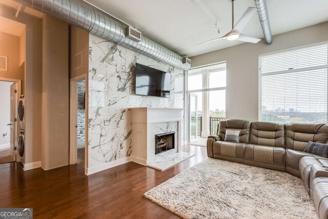 3820 Roswell Rd NE Unit 902, Atlanta, GA 30342 - living area featuring a premium fireplace, dark wood-style floors, stacked washer / dryer, baseboards, and visible vents