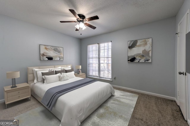 bedroom with baseboards, a ceiling fan, carpet floors, and a textured ceiling