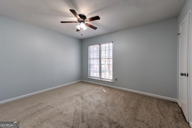 carpeted empty room with baseboards, a textured ceiling, and ceiling fan