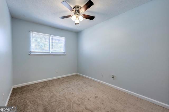 empty room with carpet flooring, a ceiling fan, baseboards, and a textured ceiling