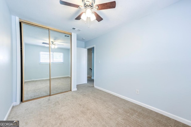 unfurnished bedroom featuring a closet, carpet flooring, visible vents, baseboards, and ceiling fan