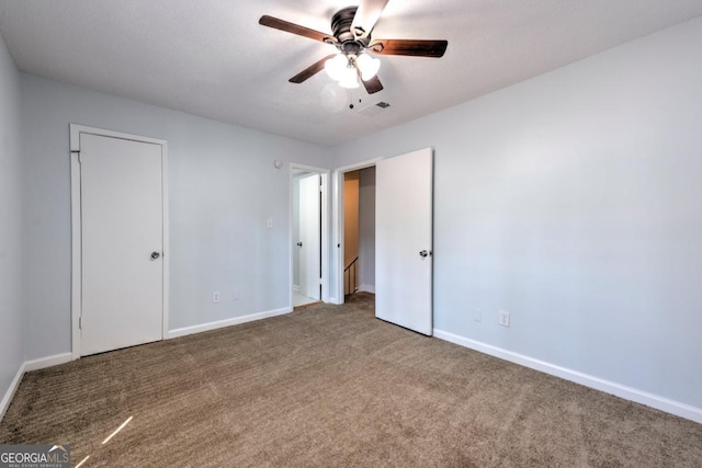 unfurnished bedroom with carpet floors, baseboards, ceiling fan, and visible vents