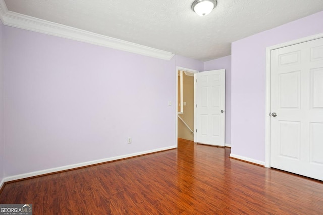 810 Abbotts Mill Ct Unit 83, Duluth, GA 30097 - unfurnished bedroom featuring baseboards, a textured ceiling, wood finished floors, and crown molding
