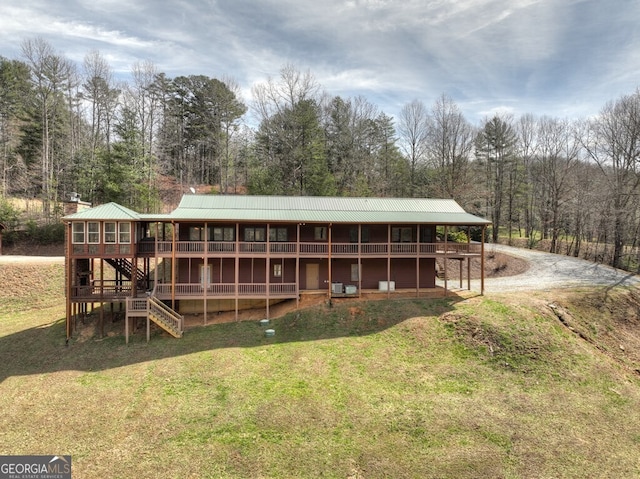 back of property with metal roof and stairs