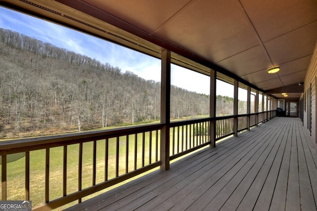 deck featuring a wooded view and a yard