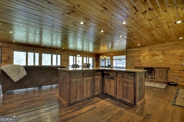 kitchen featuring recessed lighting, open floor plan, wooden walls, a kitchen island, and dark wood-type flooring
