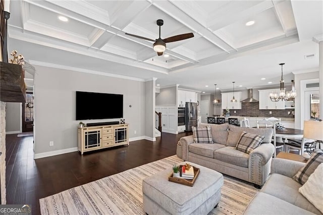 living room featuring coffered ceiling, ceiling fan with notable chandelier, beamed ceiling, ornamental molding, and dark wood-style flooring