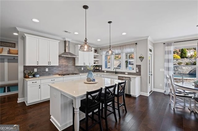 kitchen featuring light countertops, dishwasher, open shelves, wall chimney range hood, and gas stovetop
