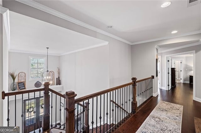 corridor featuring an upstairs landing, an inviting chandelier, ornamental molding, baseboards, and hardwood / wood-style flooring