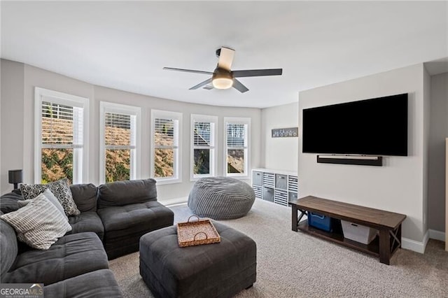 living area featuring a ceiling fan, carpet, and baseboards