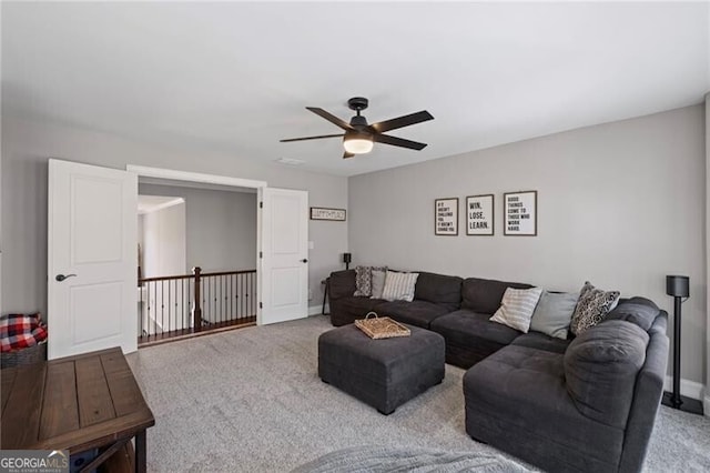 carpeted living area with ceiling fan