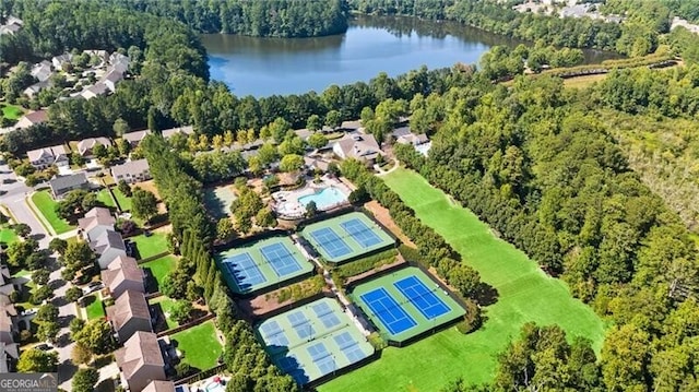 birds eye view of property with a wooded view and a water view