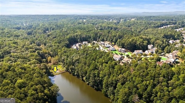 aerial view with a water view and a forest view