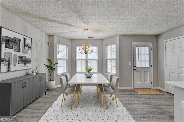 2892 Norfair Loop NE, Lithonia, GA 30038 - dining room with baseboards, a textured ceiling, light wood-style flooring, and an inviting chandelier