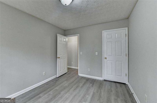 2892 Norfair Loop NE, Lithonia, GA 30038 - unfurnished bedroom with baseboards, wood finished floors, and a textured ceiling