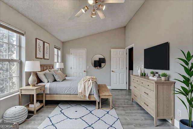 2892 Norfair Loop NE, Lithonia, GA 30038 - bedroom featuring a textured ceiling, baseboards, a ceiling fan, lofted ceiling, and light wood-style floors