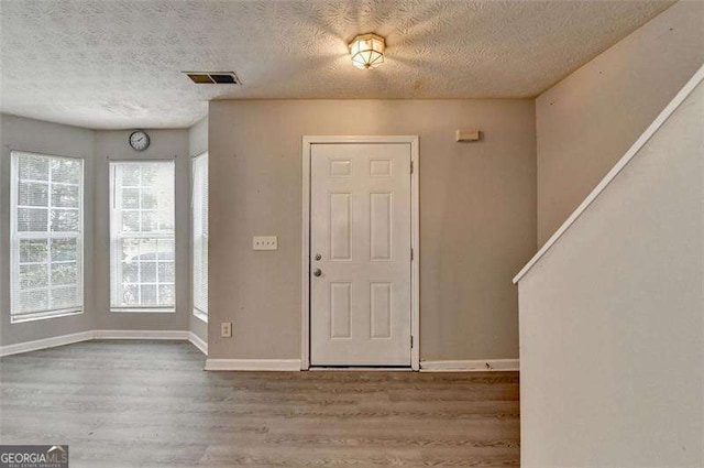 2892 Norfair Loop NE, Lithonia, GA 30038 - entryway featuring wood finished floors, a textured ceiling, baseboards, and visible vents