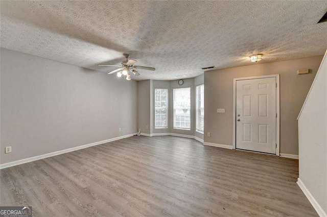 2892 Norfair Loop NE, Lithonia, GA 30038 - unfurnished living room with baseboards, visible vents, wood finished floors, and ceiling fan