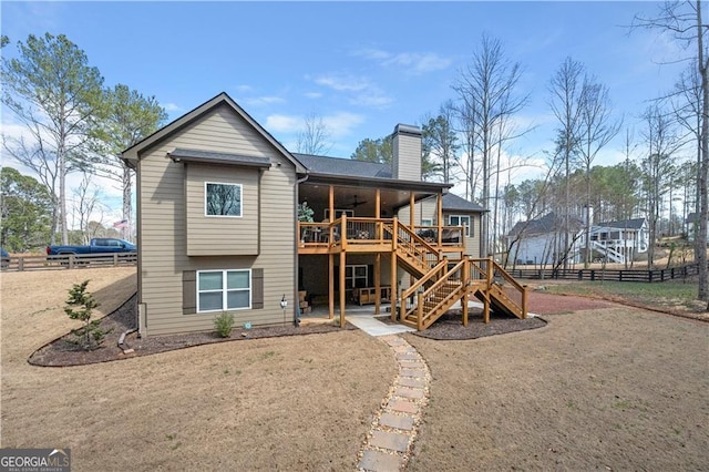 rear view of property with a chimney, fence, ceiling fan, a deck, and stairway